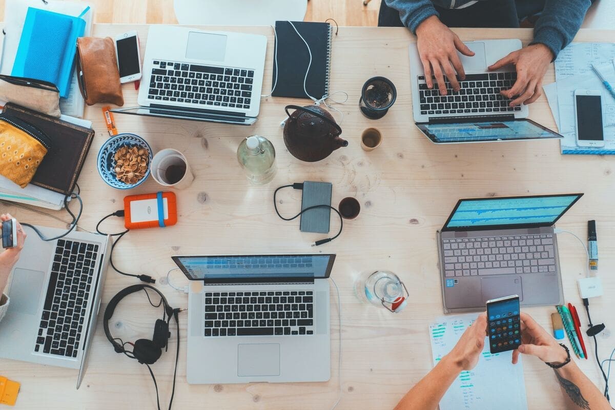 a table with five MacBooks